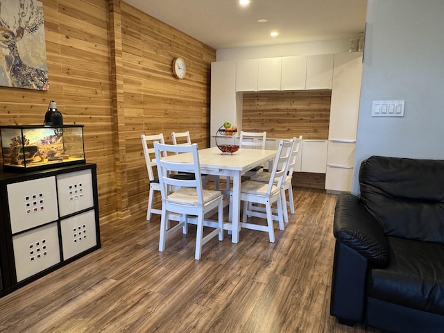 dining area featuring wooden walls, recessed lighting, and wood finished floors