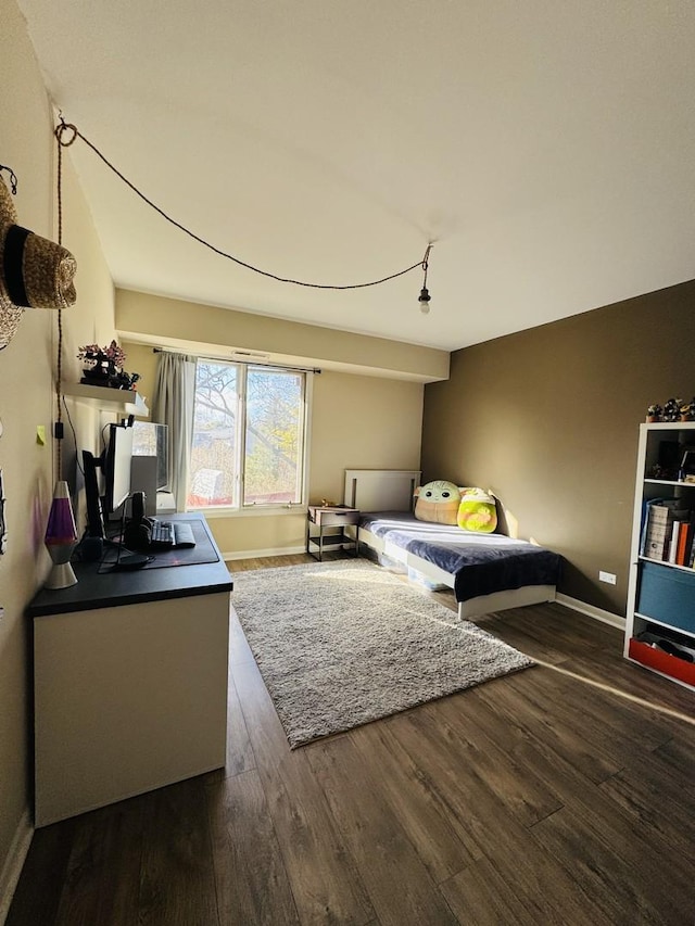 bedroom with wood finished floors and baseboards