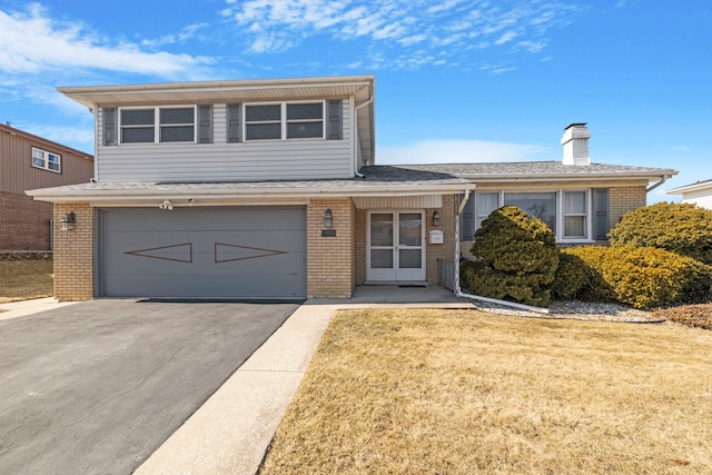 tri-level home featuring a front yard, brick siding, an attached garage, and driveway