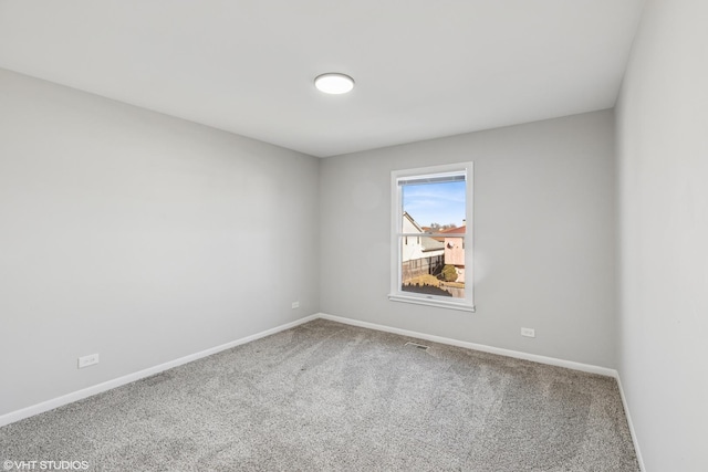 carpeted spare room featuring visible vents and baseboards