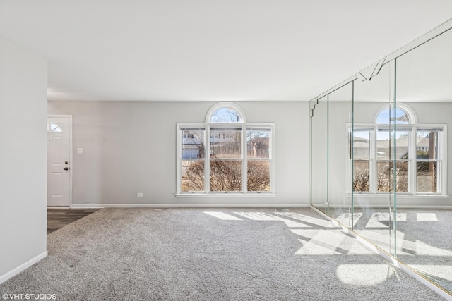 carpeted empty room featuring baseboards