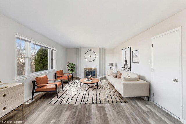 unfurnished living room with a fireplace, wood finished floors, visible vents, and baseboards