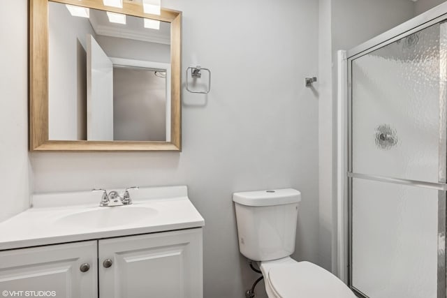 bathroom featuring toilet, a stall shower, and vanity