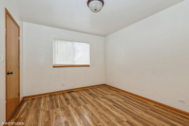 unfurnished room with light wood-style flooring and baseboards