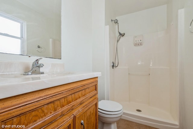 full bath featuring a shower, vanity, toilet, and tile patterned floors