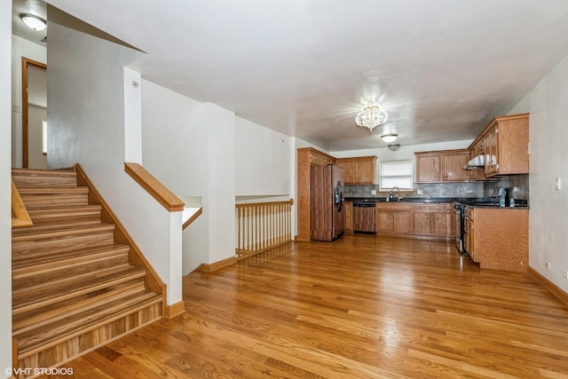 kitchen featuring dark countertops, light wood-type flooring, stainless steel appliances, and a sink