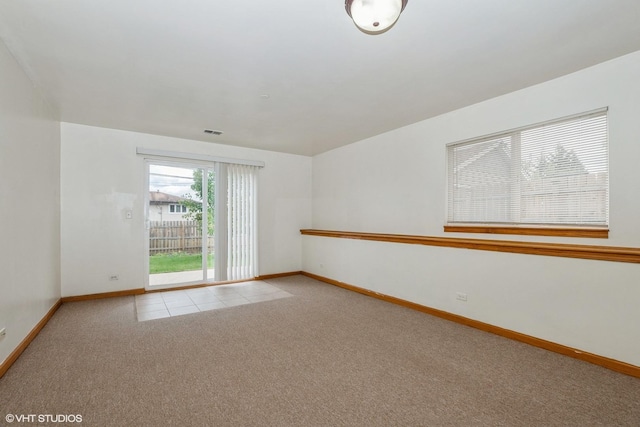 unfurnished room featuring carpet flooring, visible vents, and baseboards