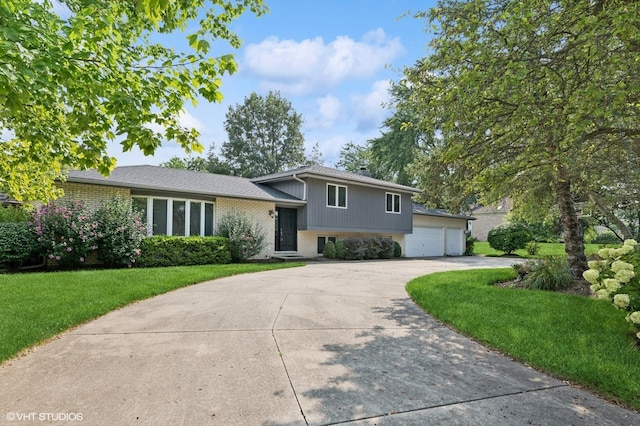 split level home with an attached garage, a front yard, concrete driveway, and brick siding