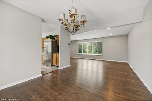 unfurnished living room with a chandelier, recessed lighting, baseboards, and wood finished floors