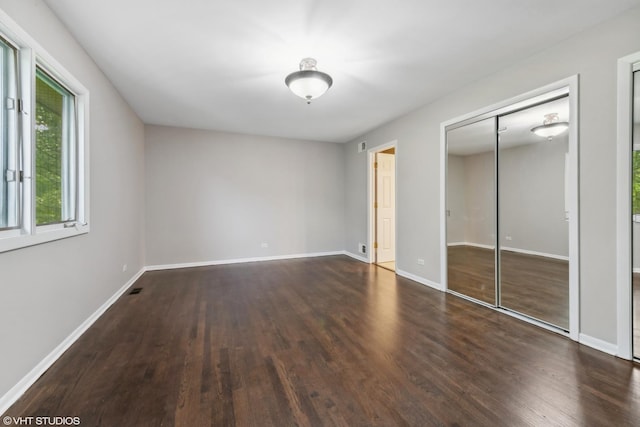 unfurnished bedroom with a closet, baseboards, and wood finished floors