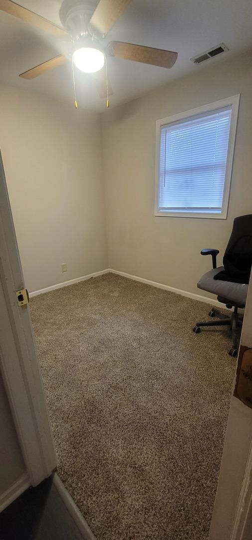 interior space featuring baseboards, carpet flooring, visible vents, and a ceiling fan