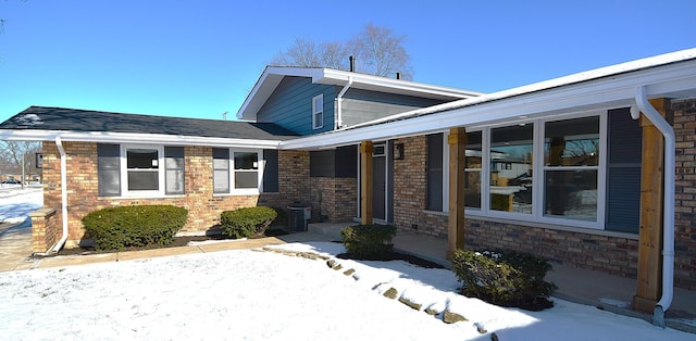 snow covered property entrance with brick siding