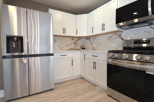 kitchen featuring stainless steel appliances, white cabinets, light wood-style floors, light countertops, and tasteful backsplash