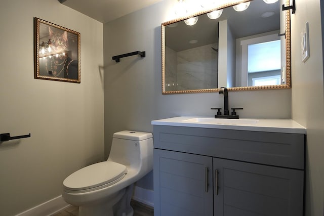 bathroom with vanity, toilet, and baseboards