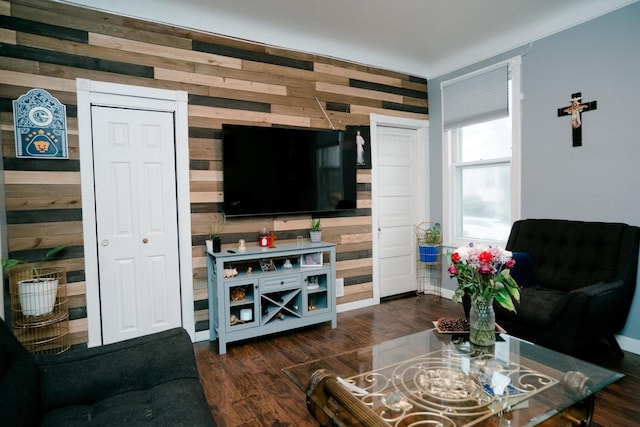 living room with dark wood finished floors and wooden walls