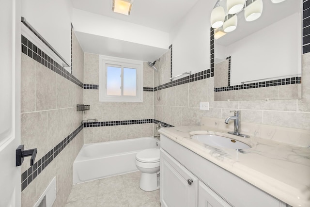 bathroom featuring toilet, vanity, tile walls, and bathing tub / shower combination