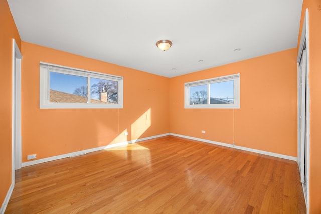 unfurnished bedroom with light wood finished floors, baseboards, and a closet