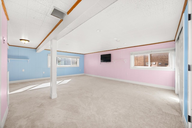 basement featuring carpet floors, ornamental molding, and baseboards