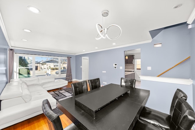 dining space with recessed lighting, wood finished floors, an inviting chandelier, and crown molding