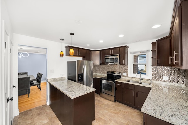 kitchen featuring appliances with stainless steel finishes, a sink, backsplash, and dark brown cabinets