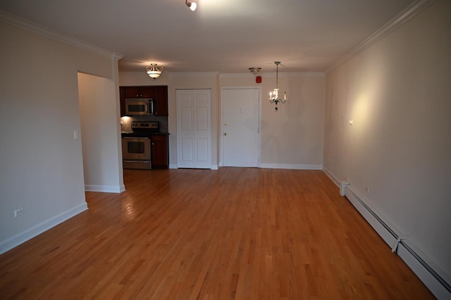 interior space with a baseboard heating unit, baseboards, wood finished floors, and crown molding