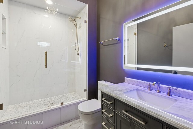 bathroom featuring a marble finish shower, marble finish floor, toilet, and vanity