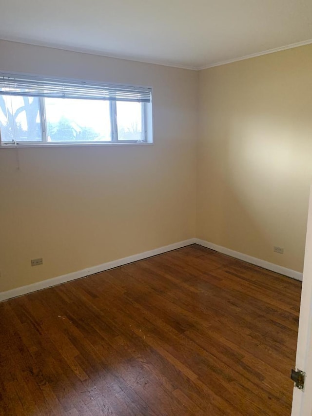 spare room with hardwood / wood-style flooring, baseboards, and ornamental molding