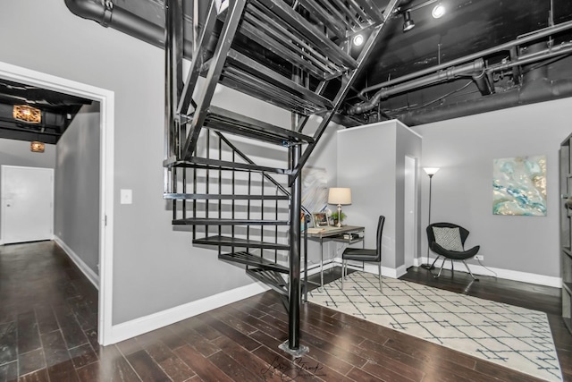 staircase with baseboards and wood finished floors