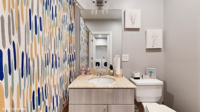 bathroom with vanity, toilet, and washer and clothes dryer