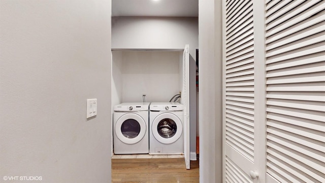 laundry area featuring laundry area, wood finished floors, and separate washer and dryer