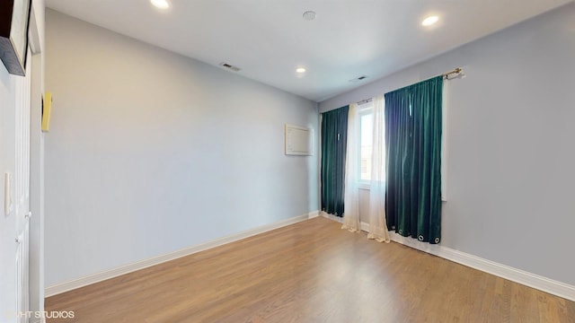 empty room with recessed lighting, visible vents, baseboards, and wood finished floors