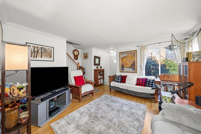 living area with stairs, ornamental molding, and light wood-style flooring