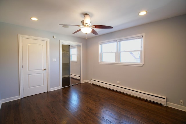 unfurnished bedroom featuring a baseboard heating unit, recessed lighting, wood finished floors, and a closet