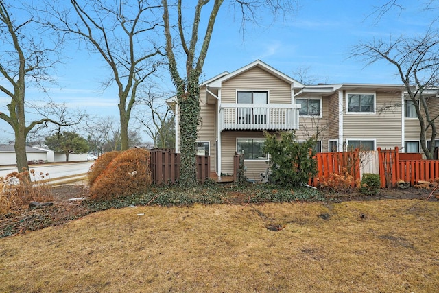 view of front of house with a balcony and fence