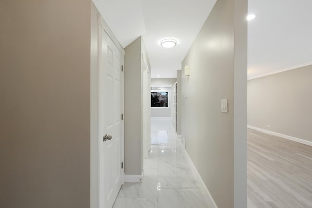 hallway with marble finish floor and baseboards