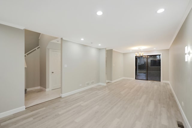 empty room featuring crown molding, baseboards, a notable chandelier, and light wood-style floors