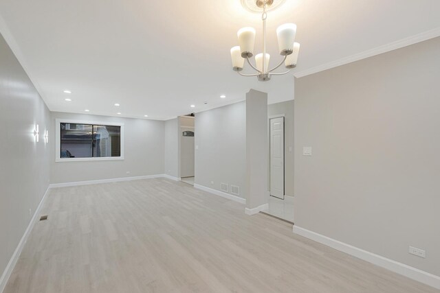 spare room featuring a chandelier, light wood finished floors, recessed lighting, and baseboards