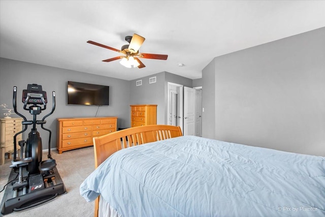 bedroom with light carpet, ceiling fan, visible vents, and baseboards