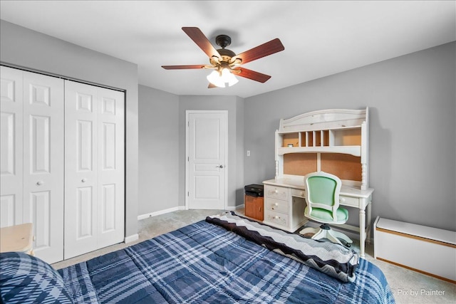 carpeted bedroom with a ceiling fan, a closet, and baseboards