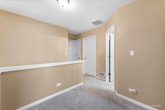 hall featuring carpet, visible vents, and baseboards