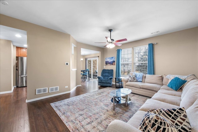 living room with baseboards, visible vents, and dark wood finished floors