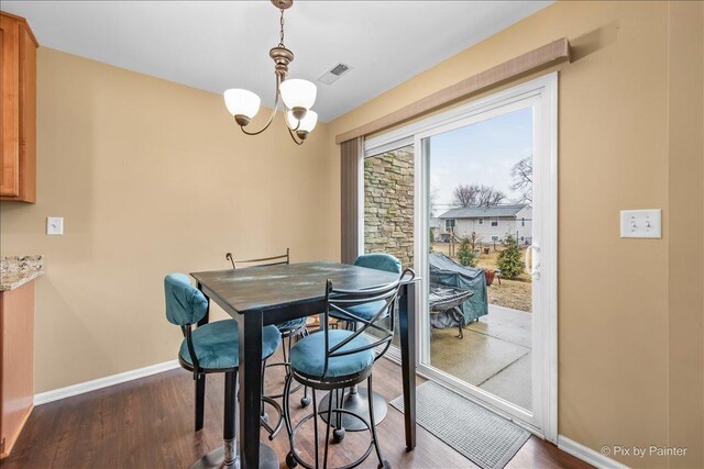 dining area with dark wood-style flooring, baseboards, and an inviting chandelier