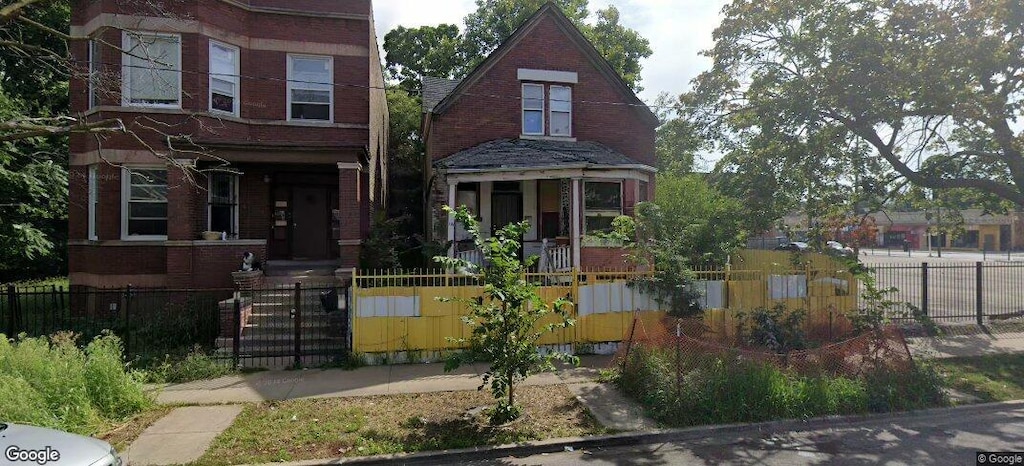 view of front of house featuring a fenced front yard, a gate, and brick siding