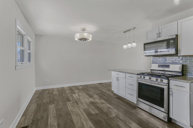 kitchen featuring baseboards, dark wood-style flooring, backsplash, and stainless steel appliances