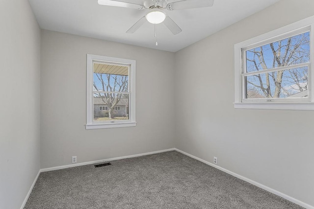 spare room featuring visible vents, carpet flooring, a ceiling fan, and baseboards