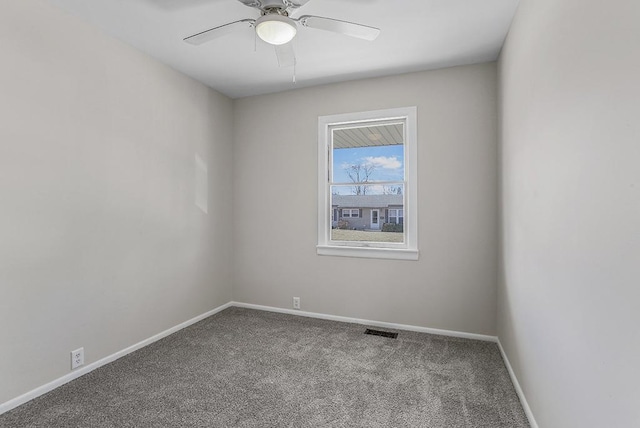 carpeted empty room with baseboards, visible vents, and ceiling fan