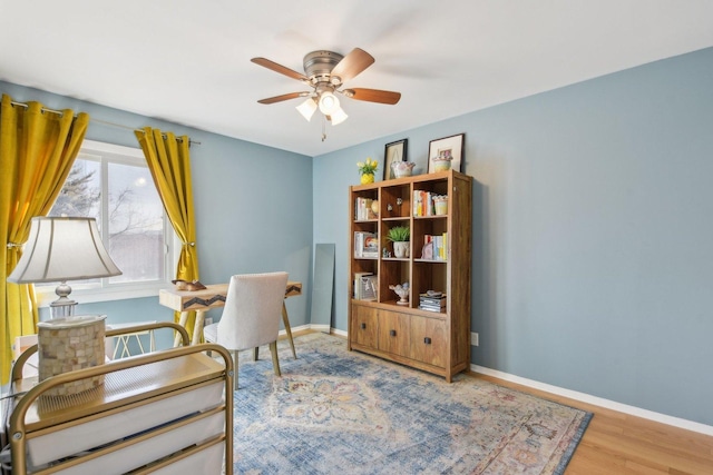 office area featuring baseboards, wood finished floors, and a ceiling fan