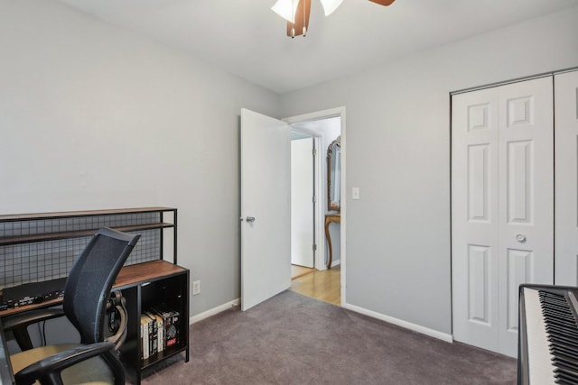 carpeted home office featuring baseboards and ceiling fan