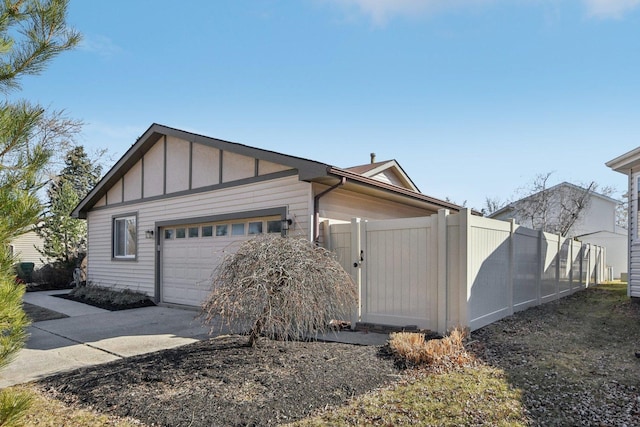 exterior space featuring concrete driveway, an attached garage, fence, and board and batten siding