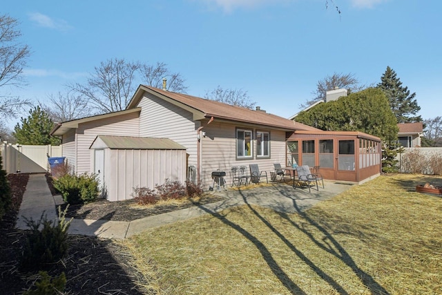 rear view of property featuring a patio, a gate, fence, an outdoor structure, and a lawn